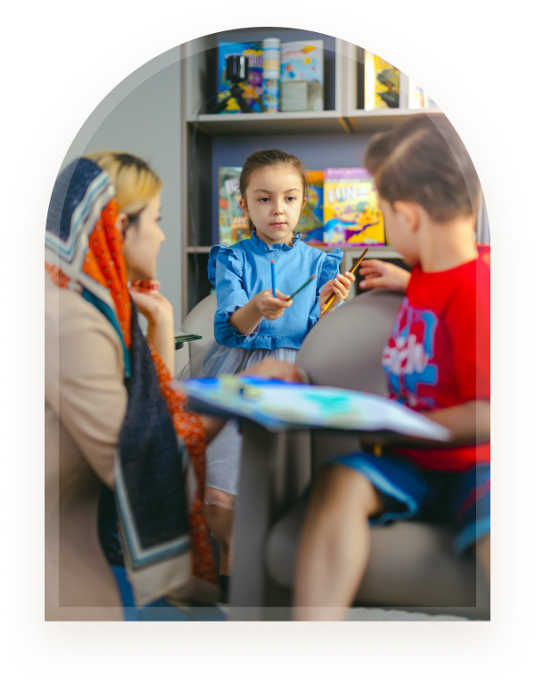 A clinician and two children engaged in a creative activity in a warm clinic setting