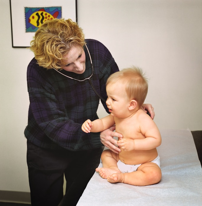 A doctor examining a baby with a stethoscope