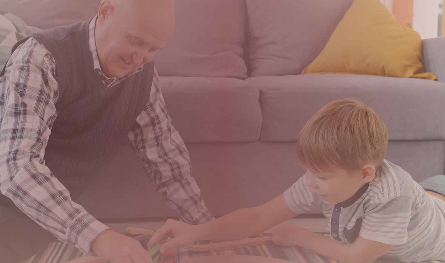 A grandfather and grandson playing together on the living room floor