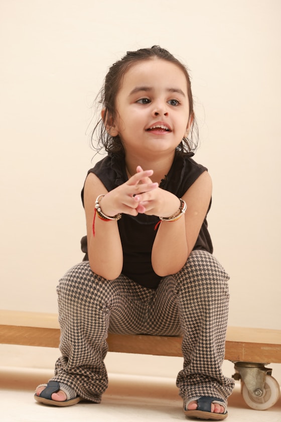 A girl smiling with her hands clasped together