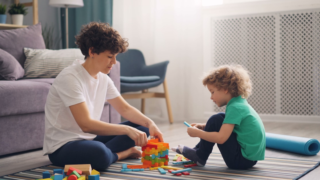 A mother and son playing with colourful building blocks