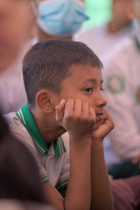 A boy resting his chin on his hands, deep in thought