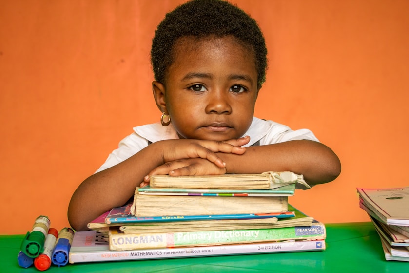 A girl resting her arms on a stack of books