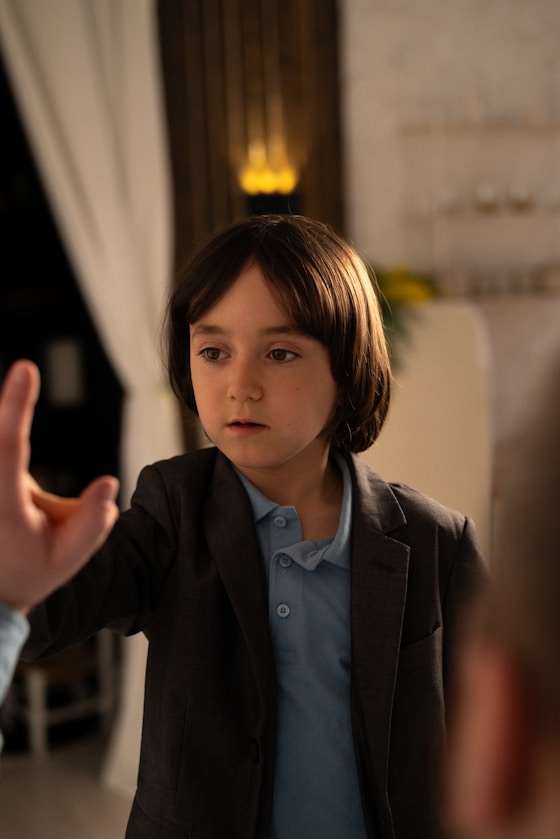 A boy reaching out a hand in a warmly lit room