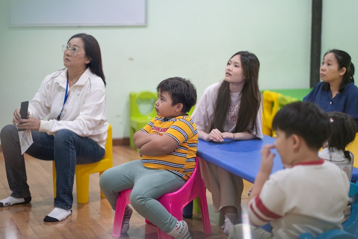 A group of adults and children in a colourful classroom setting