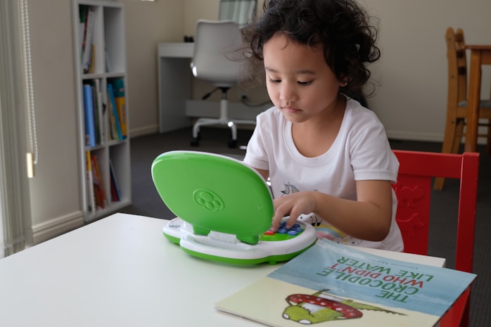 A girl playing with an interactive toy laptop