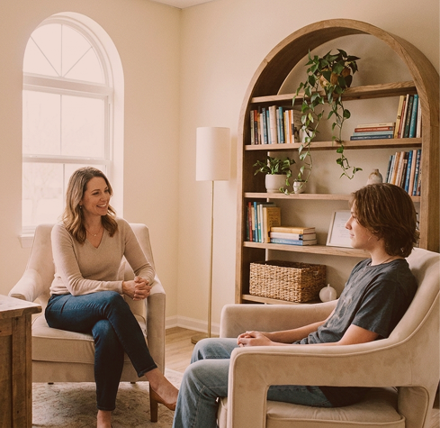 A psychiatrist talking with a teenager in a bright therapy room at Hiba by Anthalora