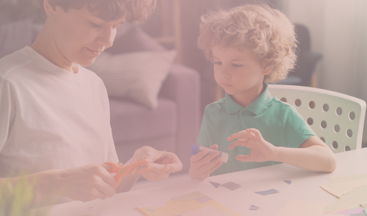 A mother and son crafting together at a table