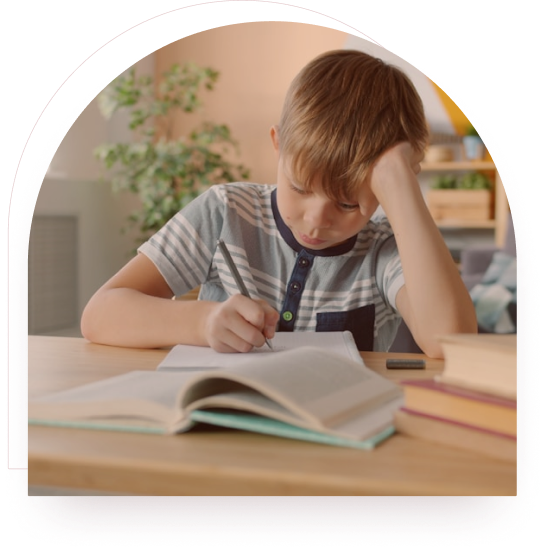 A boy concentrating on his schoolwork at a desk