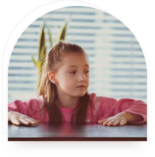 A girl looking thoughtfully out of a window at home
