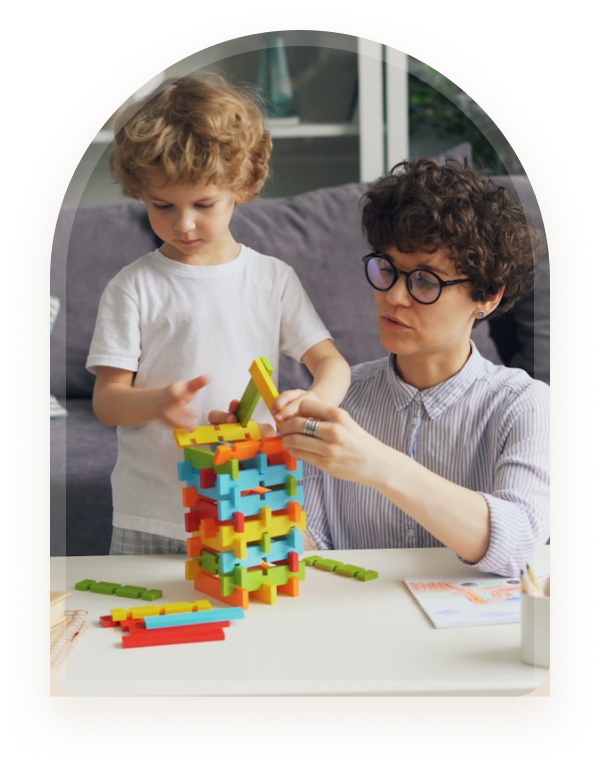 A mother and son building with colourful blocks at home