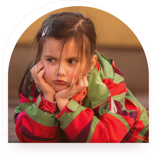 A girl resting her chin on her hands wearing a colourful jacket