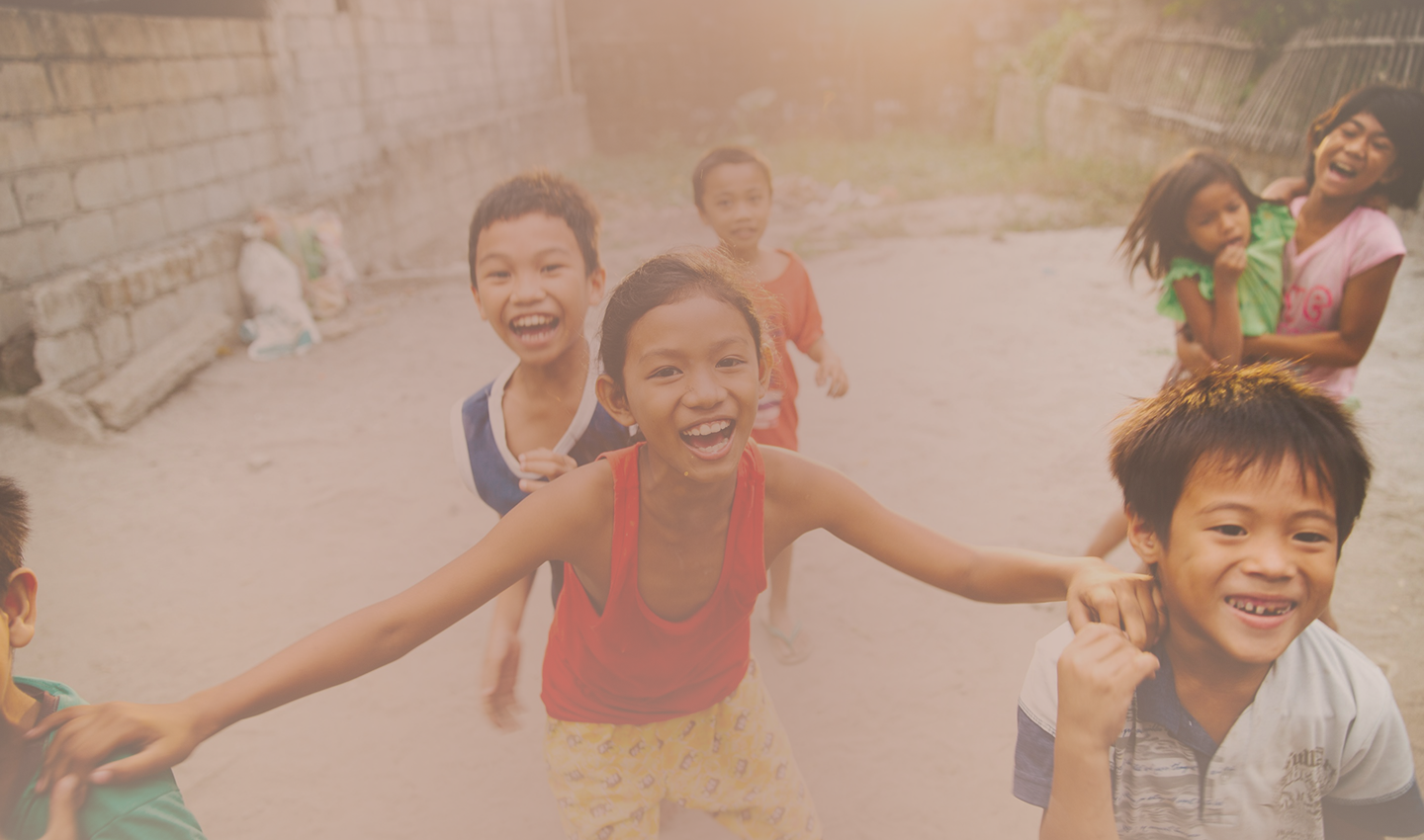 A group of children laughing and playing together outdoors