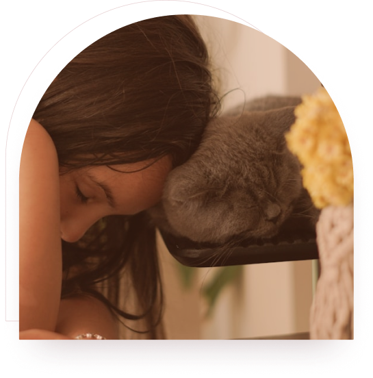 A girl resting her head against a sleeping cat