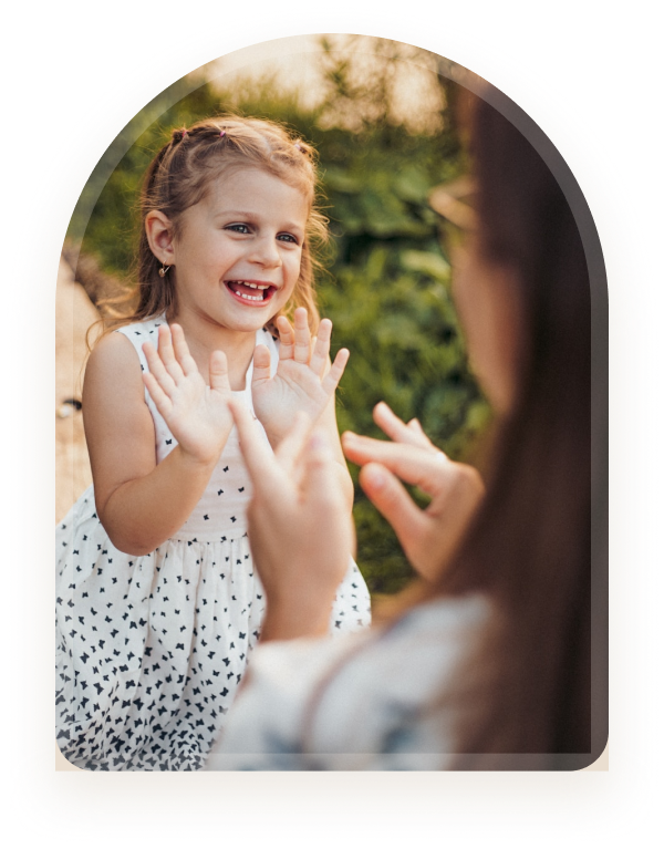 A mother and daughter using sign language together outdoors