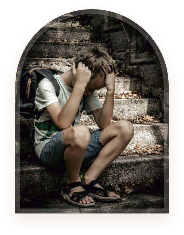 A boy sitting on steps with his head in his hands