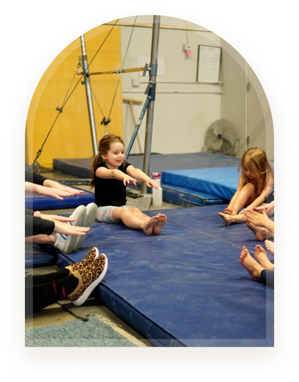 Children sitting in a circle on gym mats during a group skills workshop activity