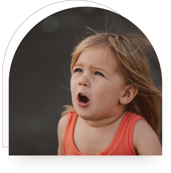 A young child looking startled outdoors